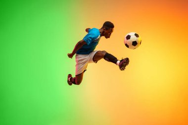 Erkek futbol, hareket halinde futbol antrenmanı neon ışıklı arka planda izole edilmiş.