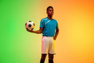 Erkek futbol, hareket halinde futbol antrenmanı neon ışıklı arka planda izole edilmiş.