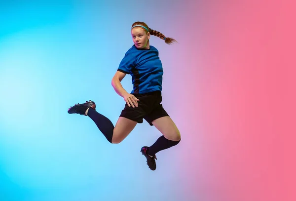 Female soccer, football player training in action isolated on gradient studio background in neon light — Stock Photo, Image