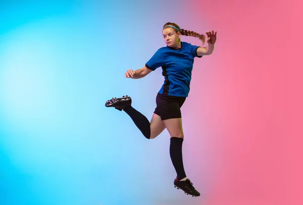 Frauenfußball, Fußballspielertraining in Aktion isoliert auf Gradienten-Studiohintergrund in Neonlicht — Stockfoto