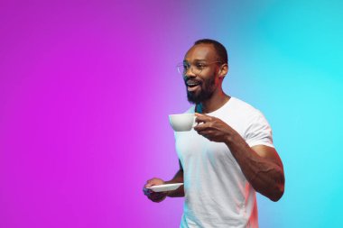 Afro-Amerikan genç adam portresi neon renkli gradyan stüdyo arka planında