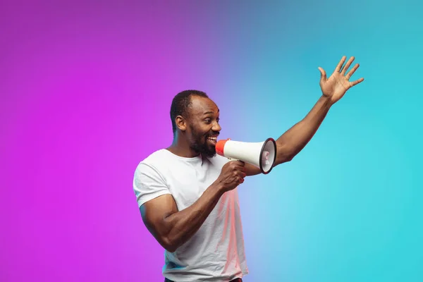 Afro-americano joven mans retrato en gradiente studio fondo en neón —  Fotos de Stock