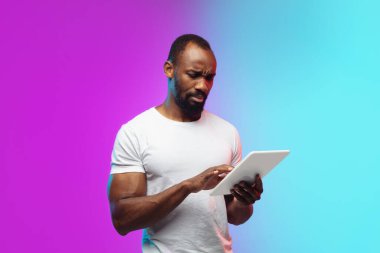Afro-Amerikan genç adam portresi neon renkli gradyan stüdyo arka planında