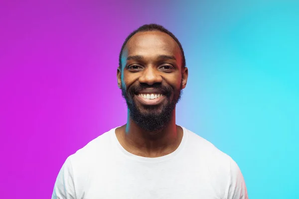 Africano-americano jovem homem retrato no gradiente estúdio fundo em néon, close up — Fotografia de Stock