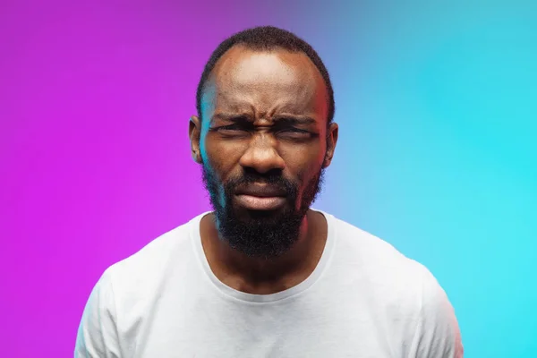 Africano-americano jovem homem retrato no gradiente estúdio fundo em néon, close up — Fotografia de Stock