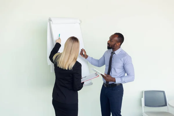 Joven hombre de negocios que trabaja con un colega usando rotafolio, copyspace — Foto de Stock