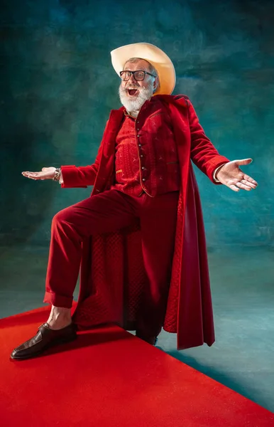 Modern stylish Santa Claus in red fashionable suit and cowboys hat on dark background — Stock Photo, Image