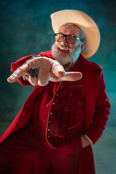 Moderno y elegante Santa Claus en traje rojo de moda y sombrero de vaqueros sobre fondo oscuro — Foto de Stock