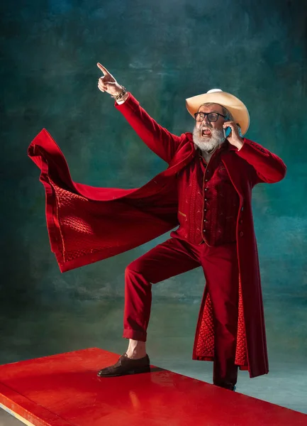 Moderno Papai Noel elegante em terno elegante vermelho e chapéu de cowboys no fundo escuro — Fotografia de Stock
