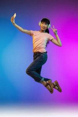 Asyalı genç kadın portresi neon renkli gradyan stüdyo arka planında