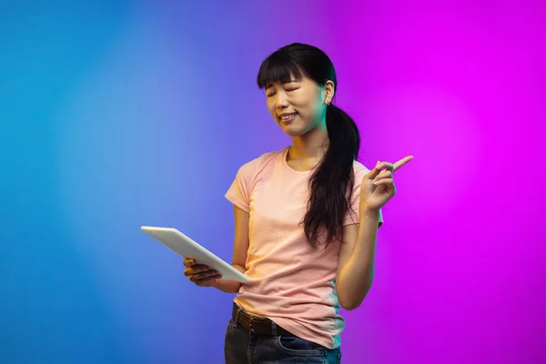 Asijské mladé ženy portrét na gradient studio pozadí v neonu — Stock fotografie