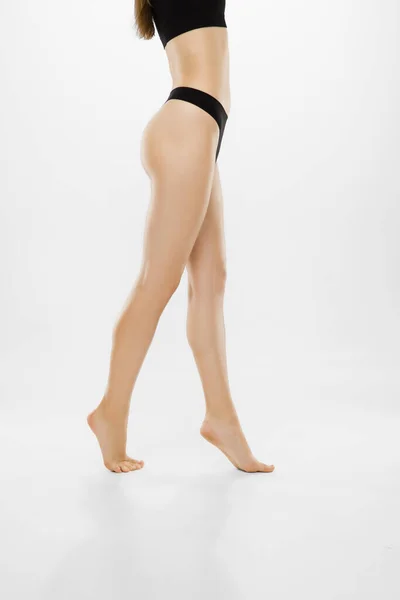 Güzel kadın bacakları ve beyaz arka planda izole edilmiş bir göbek. Güzellik, kozmetik, spa, tüy dökücü, tedavi ve spor konsepti. — Stok fotoğraf
