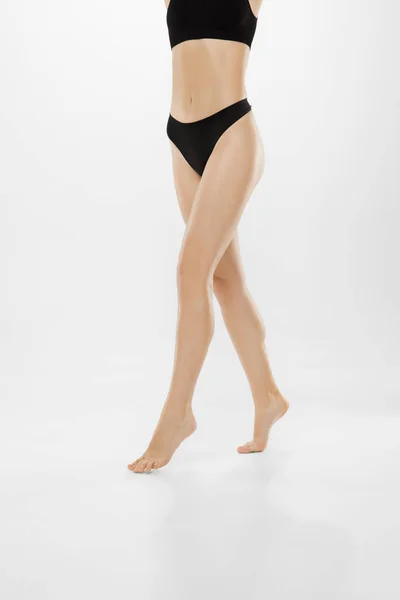 Belles jambes féminines et ventre isolé sur fond blanc. Beauté, cosmétique, spa, épilation, traitement et concept de fitness. — Photo