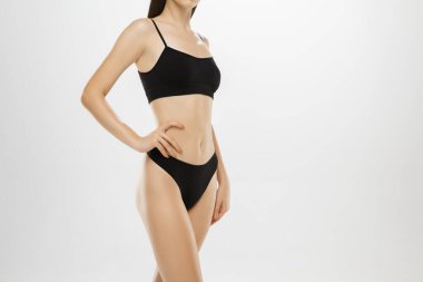 Güzel kadın bacakları ve beyaz arka planda izole edilmiş bir göbek. Güzellik, kozmetik, spa, tüy dökücü, tedavi ve spor konsepti.