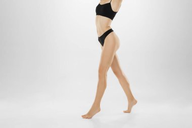 Güzel kadın bacakları ve beyaz arka planda izole edilmiş bir göbek. Güzellik, kozmetik, spa, tüy dökücü, tedavi ve spor konsepti.