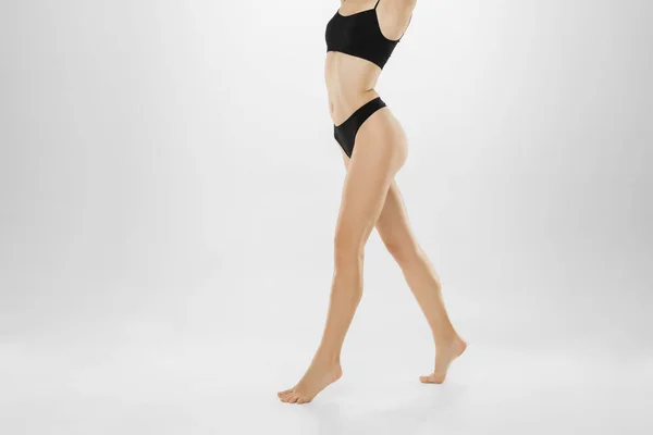 Pernas femininas bonitas e barriga isolada no fundo branco. Beleza, cosméticos, spa, depilação, tratamento e conceito de fitness. — Fotografia de Stock