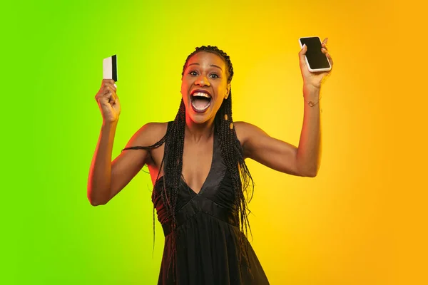 Portret van jonge vrouw in neon licht op gradiënt achterzijde. De menselijke emoties, zwarte vrijdag, cyber maandag, aankopen, verkoop, financiën concept. — Stockfoto