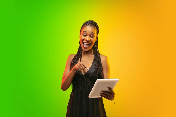 Portret van jonge vrouw in neon licht op gradiënt achterzijde. De menselijke emoties, zwarte vrijdag, cyber maandag, aankopen, verkoop, financiën concept. — Stockfoto