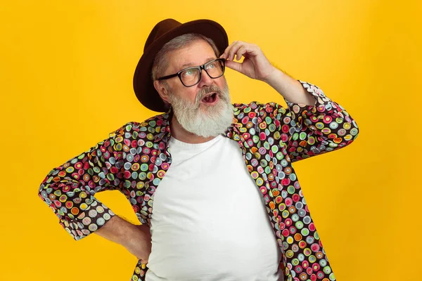 Hombre hipster senior con anteojos posando sobre fondo amarillo. Tecnología y alegre concepto de estilo de vida de ancianos — Foto de Stock