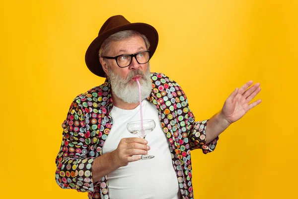 Hombre hipster senior con anteojos posando sobre fondo amarillo. Tecnología y alegre concepto de estilo de vida de ancianos — Foto de Stock