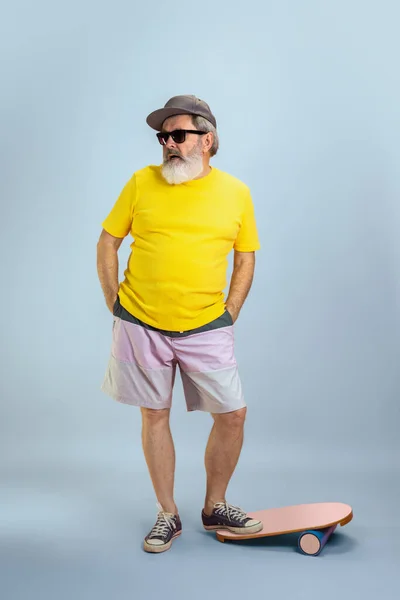 Senior hipster man met bril poserend op lichtblauwe achtergrond. Technisch en vrolijk ouderenlevensstijl concept — Stockfoto