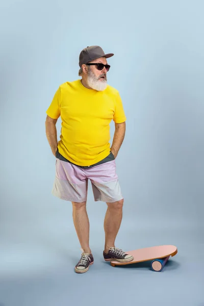Älterer Hipster-Mann mit Brille posiert auf hellblauem Hintergrund. Tech und lebensfrohes Lebensstil-Konzept für Senioren — Stockfoto