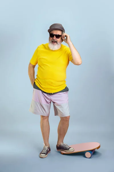 Senior hipster man met bril poserend op lichtblauwe achtergrond. Technisch en vrolijk ouderenlevensstijl concept — Stockfoto
