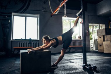 Spor salonunda sıkı çalışan bayan sporcu. Fitness ve sağlıklı yaşam konsepti.