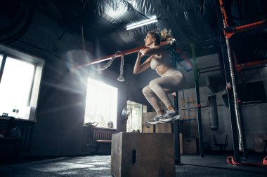 Spor salonunda sıkı çalışan bayan sporcu. Fitness ve sağlıklı yaşam konsepti.