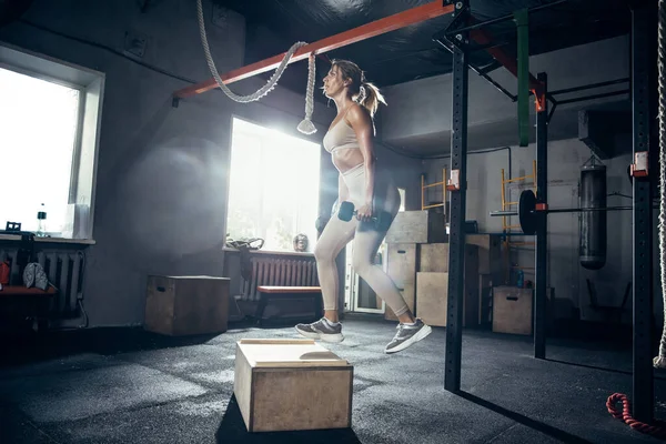 Spor salonunda sıkı çalışan bayan sporcu. Fitness ve sağlıklı yaşam konsepti. — Stok fotoğraf