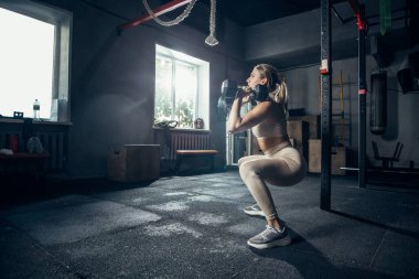 Spor salonunda sıkı çalışan bayan sporcu. Fitness ve sağlıklı yaşam konsepti.