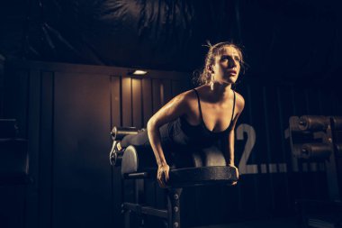 Spor salonunda sıkı çalışan bayan sporcu. Fitness ve sağlıklı yaşam konsepti.