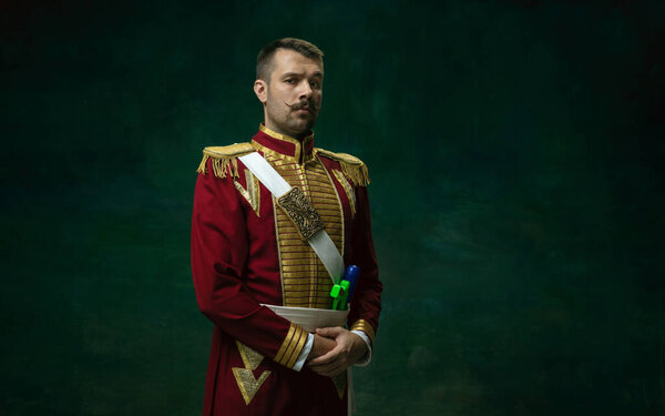 Young man as Nicholas II on dark green background. Retro style, comparison of eras concept.