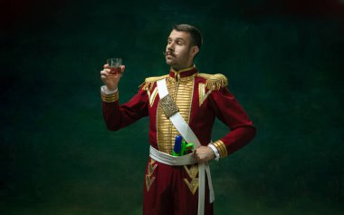 Nicholas II gibi koyu yeşil arka planda genç bir adam. Retro biçimi, dönemin karşılaştırması.