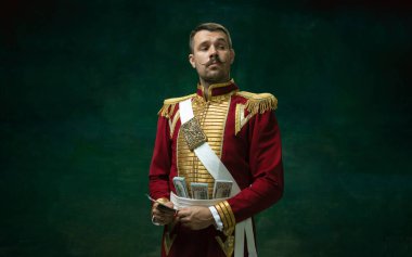 Nicholas II gibi koyu yeşil arka planda genç bir adam. Retro biçimi, dönemin karşılaştırması.