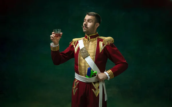 Junger Mann als Nikolaus II. auf dunkelgrünem Grund. Retro-Stil, Vergleich des Epochenkonzepts. — Stockfoto