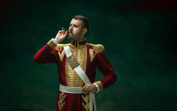 Mladý muž jako Nicholas II na tmavozeleném pozadí. Retro styl, srovnání konceptu éry. — Stock fotografie