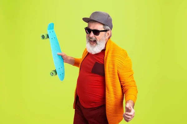 Uomo anziano hipster indossa occhiali in posa su sfondo verde. Tecnologia e gioioso stile di vita anziano concetto — Foto Stock