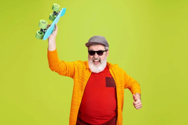 Senior hipster man met een bril die poseert op een groene achtergrond. Technisch en vrolijk ouderenlevensstijl concept — Stockfoto