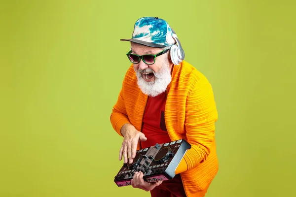 Uomo anziano hipster indossa occhiali in posa su sfondo verde. Tecnologia e gioioso stile di vita anziano concetto — Foto Stock