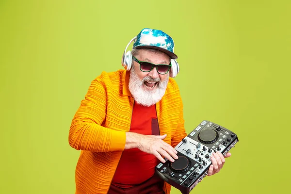 Uomo anziano hipster indossa occhiali in posa su sfondo verde. Tecnologia e gioioso stile di vita anziano concetto — Foto Stock