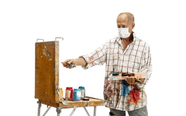 Ressam, iş yerindeki ressam beyaz stüdyo arka planında izole edilmiş.