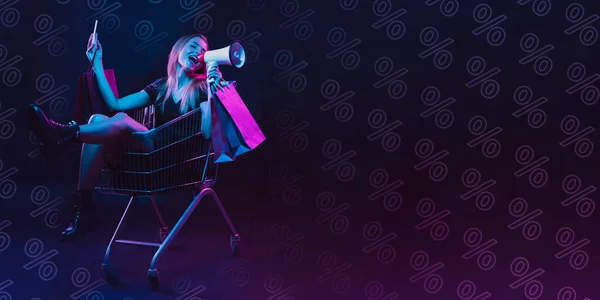 Porträt einer jungen Frau im Neonlicht auf dunklem Hintergrund. Die menschlichen Emotionen, Black Friday, Cyber Monday, Einkäufe, Verkäufe, Finanzkonzept. Neon-Schriftzug. — Stockfoto