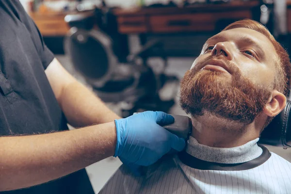 Hombre que se corta el pelo en la barbería usando máscara durante la pandemia de coronavirus —  Fotos de Stock