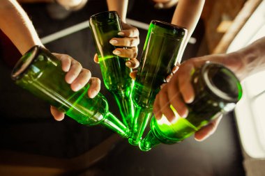 Bir grup genç arkadaş bira içiyor, eğleniyor, gülüyor ve birlikte kutluyorlar. Bira şişelerini tıkırdat.