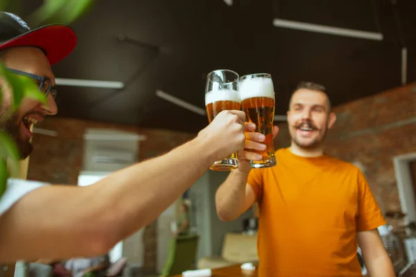 Jonge vrienden die bier drinken, plezier hebben, lachen en samen feesten. Sluiten klinkende bierflessen — Stockfoto