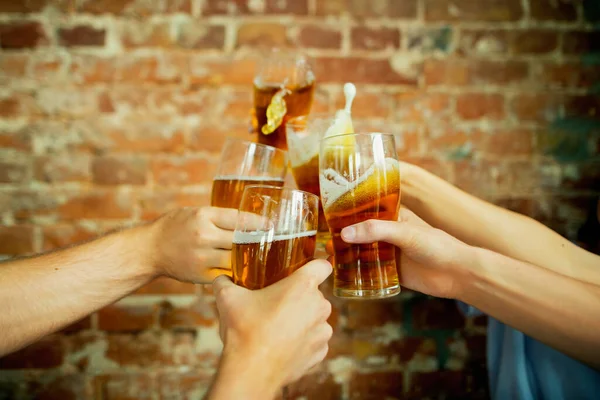 Jovem grupo de amigos bebendo cerveja, se divertindo, rindo e comemorando juntos. Fechar os copos de cerveja — Fotografia de Stock