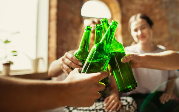 Jonge vrienden die bier drinken, plezier hebben, lachen en samen feesten. Sluiten klinkende bierflessen — Stockfoto