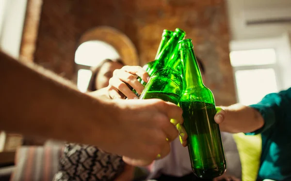 Joven grupo de amigos bebiendo cerveza, divirtiéndose, riéndose y celebrando juntos. Cerca de tintineo botellas de cerveza —  Fotos de Stock