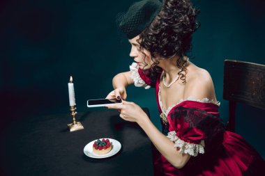 Koyu mavi arka planda Anna Karenina gibi genç bir kadın. Retro biçimi, dönemin karşılaştırması.